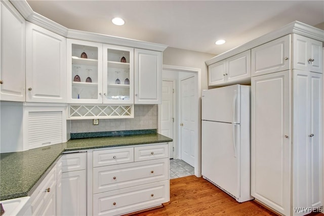 4179 Foxwood Ln, Clarence, NY 14221 - kitchen featuring freestanding refrigerator, white cabinetry, glass insert cabinets, backsplash, and light wood-type flooring