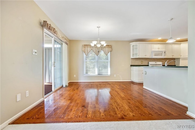 4179 Foxwood Ln, Clarence, NY 14221 - kitchen featuring white microwave, range, wood finished floors, white cabinetry, and dark countertops