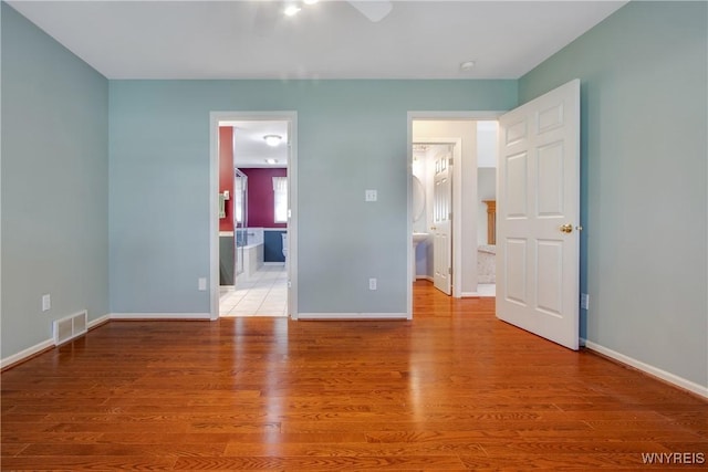 4179 Foxwood Ln, Clarence, NY 14221 - unfurnished bedroom with ensuite bath, baseboards, and wood finished floors