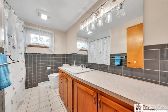20 Post Rd, Amherst, NY 14221 - bathroom with tile walls, tile patterned flooring, toilet, vanity, and a wainscoted wall