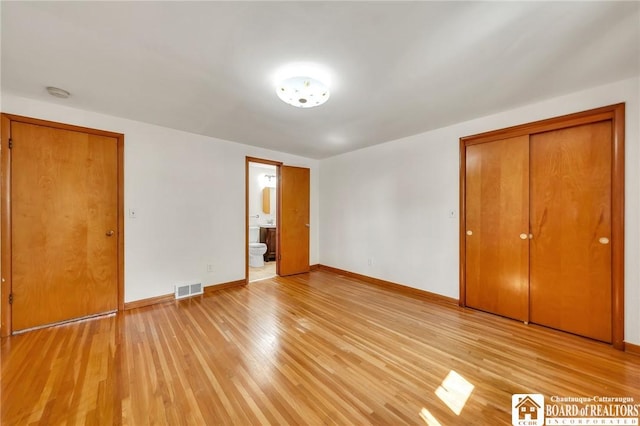 20 Post Rd, Amherst, NY 14221 - unfurnished bedroom with baseboards, light wood-style floors, connected bathroom, and a closet