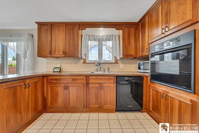 20 Post Rd, Amherst, NY 14221 - kitchen featuring black appliances, a sink, brown cabinets, light tile patterned flooring, and light countertops