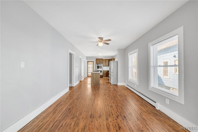 111 Roesch Ave, Buffalo, NY 14207 - unfurnished living room with a baseboard radiator, baseboards, hardwood / wood-style flooring, and a ceiling fan