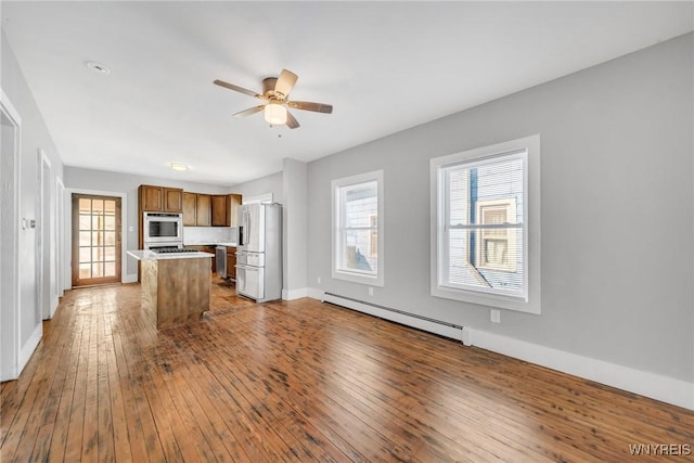 111 Roesch Ave, Buffalo, NY 14207 - kitchen featuring stainless steel appliances, a baseboard heating unit, hardwood / wood-style floors, ceiling fan, and healthy amount of natural light