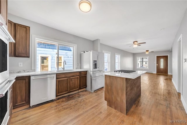 111 Roesch Ave, Buffalo, NY 14207 - kitchen with stainless steel appliances, a sink, light wood-style flooring, a center island, and ceiling fan