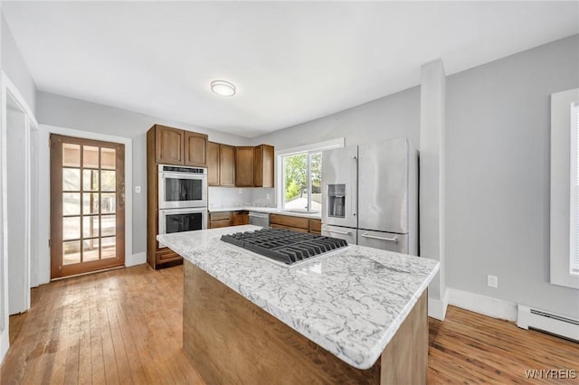 111 Roesch Ave, Buffalo, NY 14207 - kitchen featuring stainless steel appliances, a sink, a baseboard radiator, light wood-type flooring, and a center island