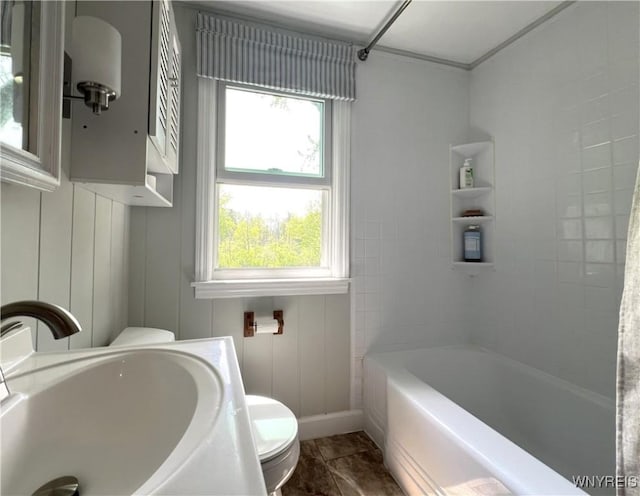 bathroom featuring healthy amount of natural light, toilet, a sink, and  shower combination