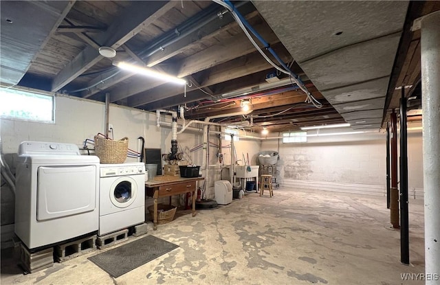 basement featuring independent washer and dryer and a sink