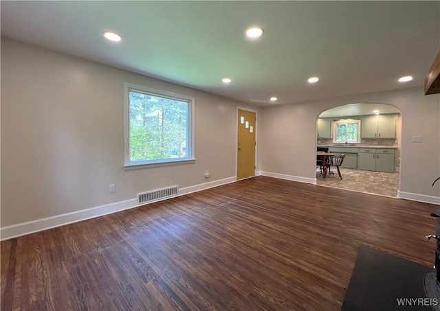 entryway featuring arched walkways, recessed lighting, dark wood-style flooring, and baseboards