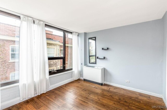 849 Delaware Ave Unit 305, Buffalo, NY 14209 - empty room featuring baseboards, wood finished floors, and heating unit