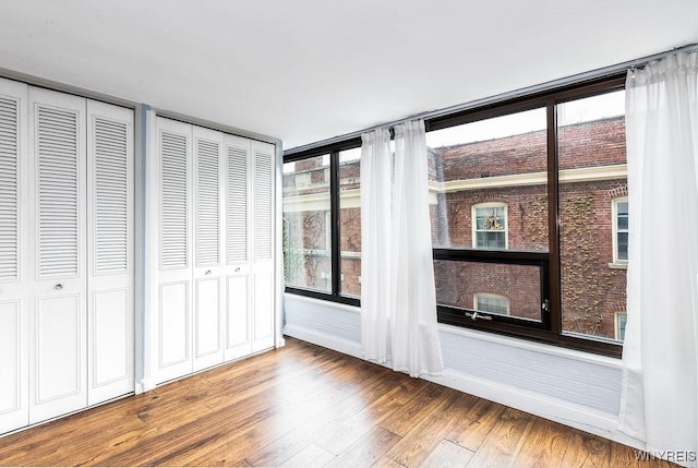 849 Delaware Ave Unit 305, Buffalo, NY 14209 - unfurnished bedroom with wood finished floors and two closets