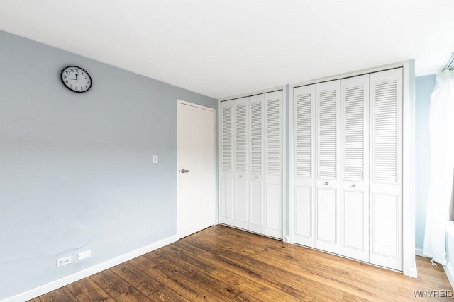 849 Delaware Ave Unit 305, Buffalo, NY 14209 - unfurnished bedroom featuring multiple closets, wood finished floors, and baseboards