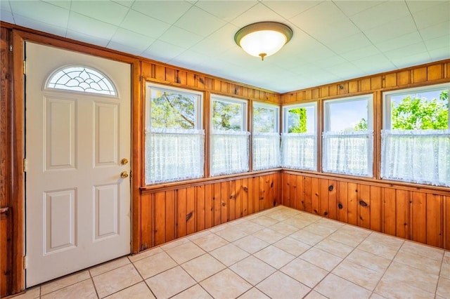unfurnished sunroom with wooden walls