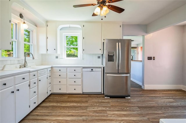 kitchen with dishwasher, stainless steel fridge, a sink, backsplash, and wood finished floors