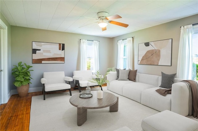 living room featuring wood finished floors, plenty of natural light, ceiling fan, and baseboards