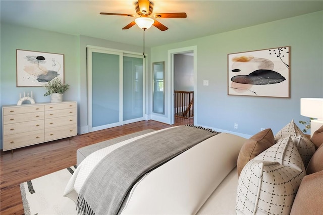 bedroom with wood finished floors, baseboards, and ceiling fan