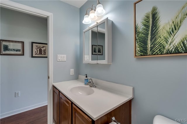 210 Funnycide Dr, Hounsfield, NY 13685 - bathroom featuring vanity, wood finished floors, baseboards, toilet, and a chandelier