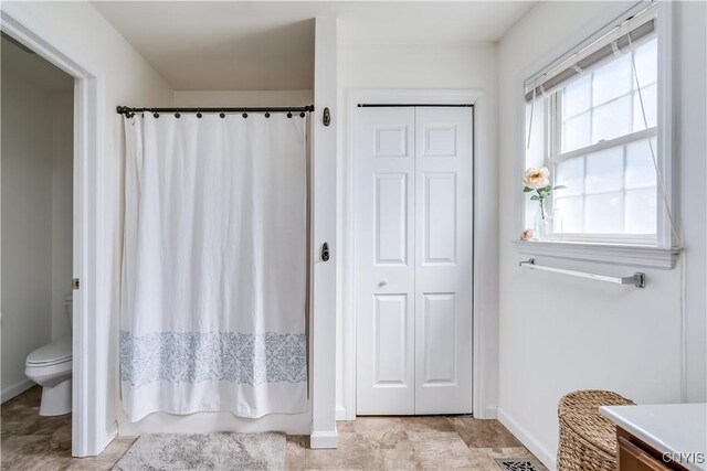 210 Funnycide Dr, Hounsfield, NY 13685 - bathroom featuring baseboards, toilet, curtained shower, and a closet
