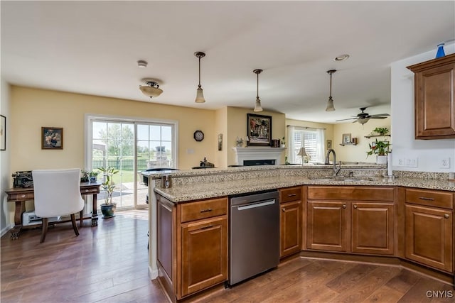 210 Funnycide Dr, Hounsfield, NY 13685 - kitchen with dishwasher, a sink, a fireplace, a ceiling fan, and light stone counters
