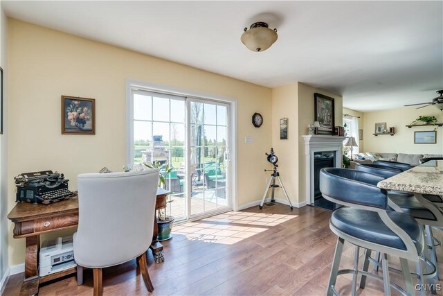210 Funnycide Dr, Hounsfield, NY 13685 - dining area with wood finished floors, a fireplace, baseboards, and ceiling fan