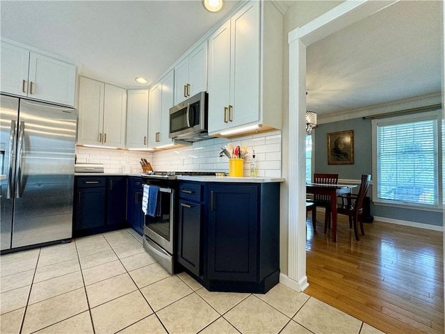 214 Fairfield Dr, Horseheads, NY 14845 - kitchen with appliances with stainless steel finishes, light countertops, backsplash, white cabinets, and ornamental molding