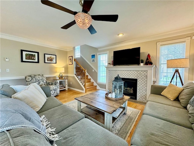 214 Fairfield Dr, Horseheads, NY 14845 - living room featuring stairs, ornamental molding, a fireplace, light wood-style flooring, and a ceiling fan