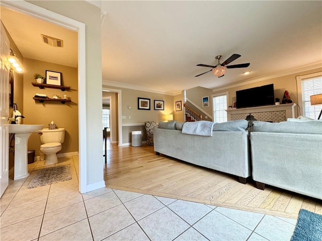 214 Fairfield Dr, Horseheads, NY 14845 - living area with light tile patterned flooring, stairs, ceiling fan, crown molding, and baseboards