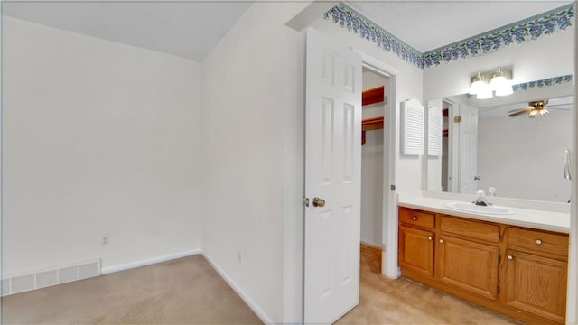 bathroom with a ceiling fan, vanity, and baseboards