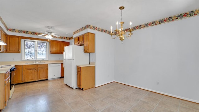 kitchen with white appliances, a sink, light countertops, ceiling fan, and a chandelier