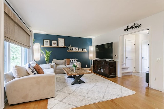 living area with wood finished floors, stairway, and baseboards