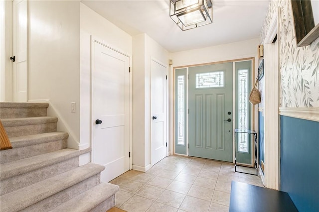 entrance foyer featuring stairway, light tile patterned floors, and baseboards