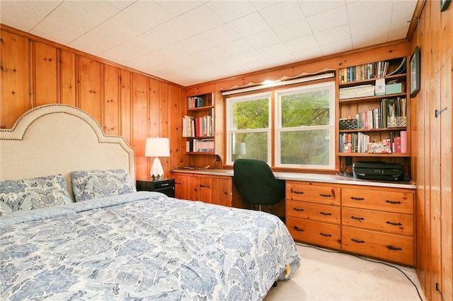 bedroom featuring wooden walls and light carpet