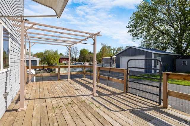 wooden terrace featuring an outdoor structure, a pergola, and a detached garage