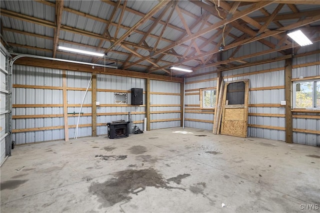 garage with metal wall, electric panel, and a wood stove