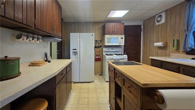 612 Reynolds St, Elmira-City, NY 14904 - kitchen with white appliances, light flooring, wooden counters, wood walls, and a paneled ceiling