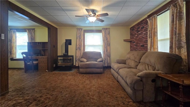 612 Reynolds St, Elmira-City, NY 14904 - carpeted living room with a wood stove, a ceiling fan, a paneled ceiling, and ornamental molding