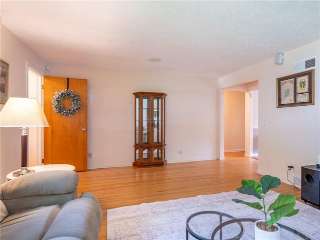 living area featuring light wood-style floors and baseboards