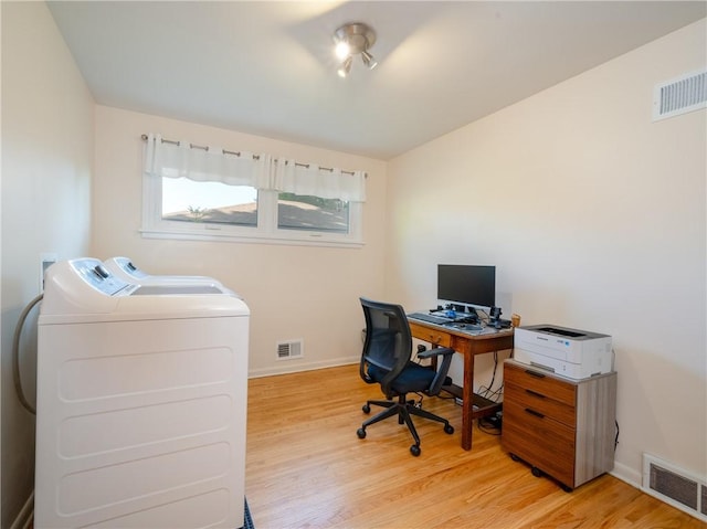 office area featuring washer and clothes dryer, light wood-style flooring, and baseboards