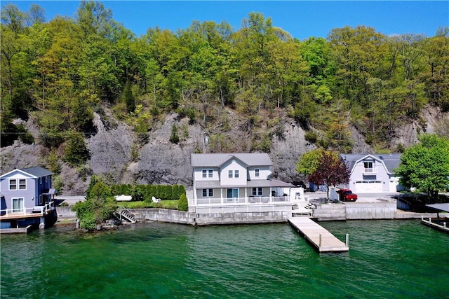 dock area with a water view and a wooded view