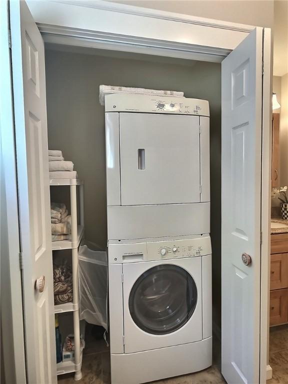 clothes washing area with estacked washer and dryer