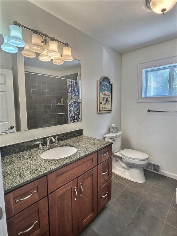 bathroom featuring tile patterned flooring, toilet, vanity, and a shower with curtain