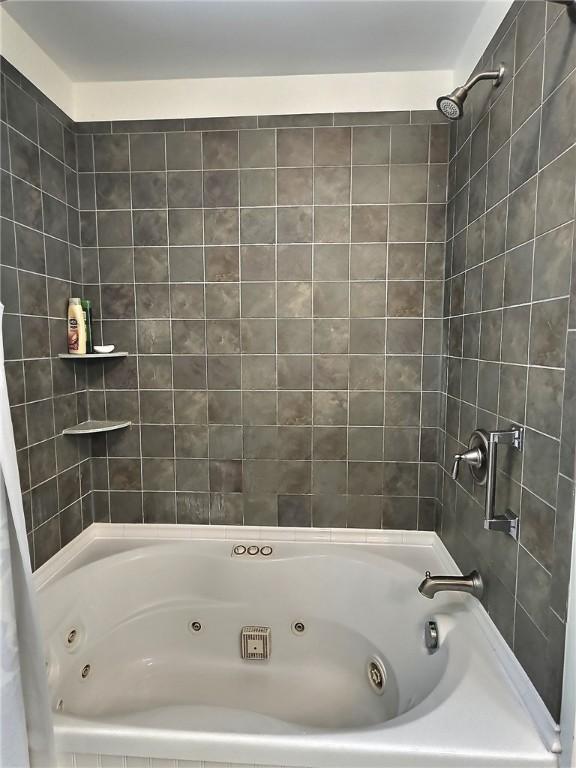 bathroom with a combined bath / shower with jetted tub