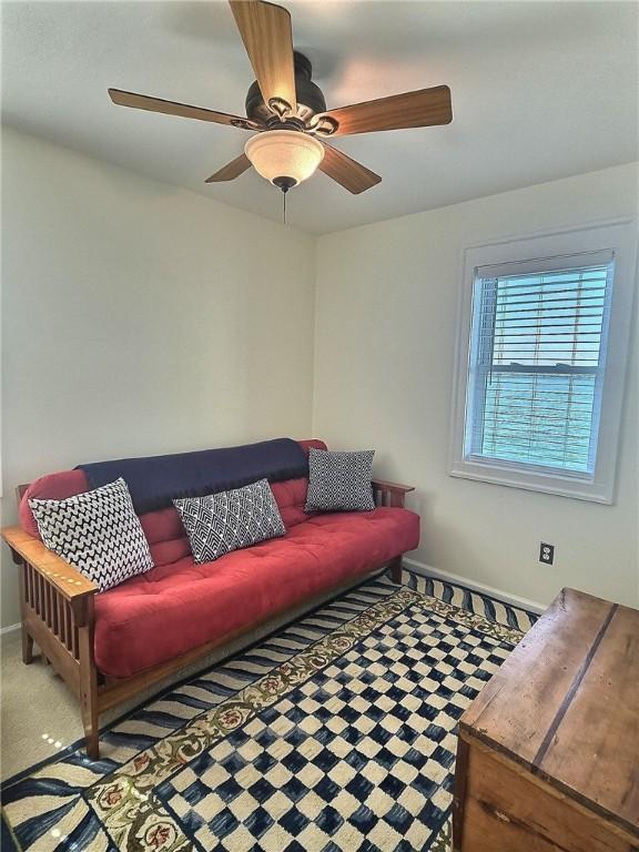 living room with baseboards and a ceiling fan