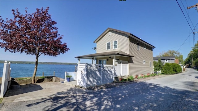 view of property exterior featuring a water view and a porch