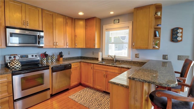 kitchen with stainless steel appliances, a sink, a peninsula, open shelves, and recessed lighting