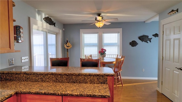 dining area featuring ceiling fan, light wood-type flooring, and baseboards