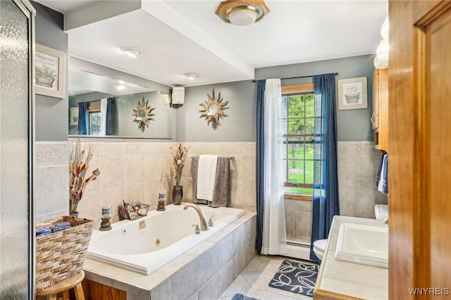 full bath featuring tile patterned floors, a tub with jets, toilet, tile walls, and vanity