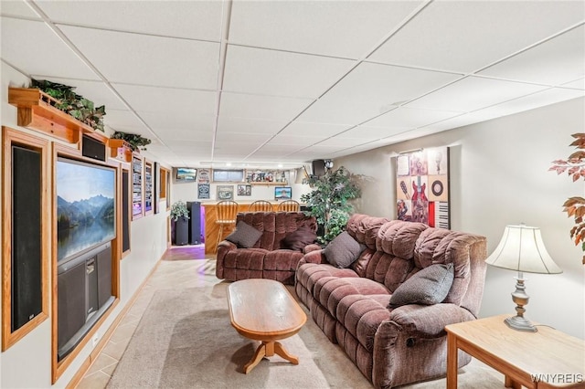 living area featuring light tile patterned flooring and a paneled ceiling