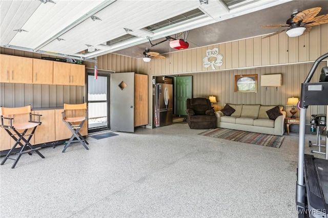 garage with freestanding refrigerator, a ceiling fan, and a garage door opener