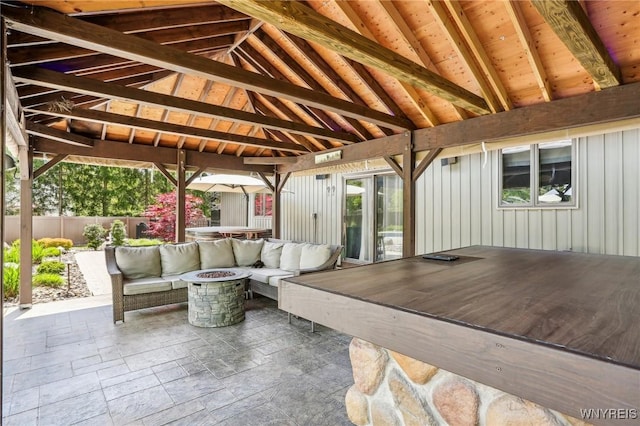 view of patio featuring an outdoor living space with a fire pit, fence, and a gazebo